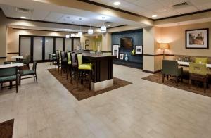 a lobby with a bar and chairs and a dining area at Hampton Inn Dahlgren in Dahlgren