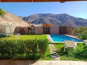 a swimming pool in a yard with mountains in the background at Refugio Guimanta in Vicuña
