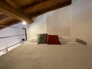 - une chambre avec un grand lit et un oreiller rouge dans l'établissement Il Loft del Lago, à Anguillara Sabazia