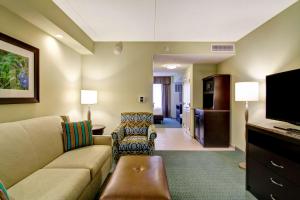 a living room with a couch and a tv at Hilton Garden Inn Woodbridge in Woodbridge