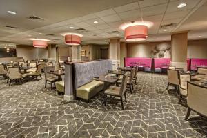 a dining room with tables and chairs and pink at DoubleTree by Hilton Decatur Riverfront in Decatur