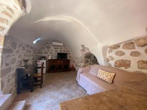 Habitación con cama y escritorio en una cueva en The Two Carob Trees, Traditional Stonehouse, Nikandri, Pirgos Diros en Levkiás