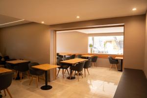um restaurante com mesas e cadeiras e uma janela em Urbana Suites em Mendoza