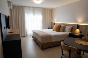 um quarto de hotel com uma cama e uma mesa em Urbana Suites em Mendoza