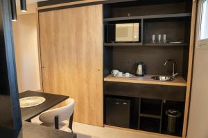 Urbana Suites في ميندوزا: مطبخ صغير مع حوض وميكروويف