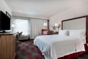 a hotel room with a bed and a flat screen tv at Hampton Inn Debary-Deltona in DeBary