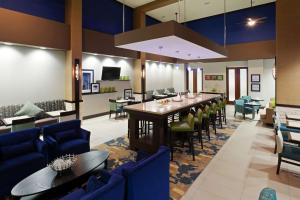 Hampton Inn & Suites Denver Airport / Gateway Park في آرورا: لوبي كبير مع طاولة وكراسي طويلة