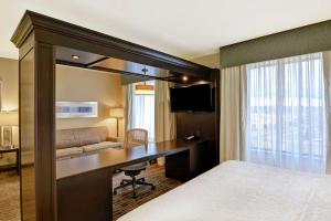 a hotel room with a desk and a bed at Hampton Inn & Suites Denver Airport / Gateway Park in Aurora