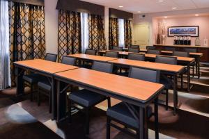 Hampton Inn & Suites Denver-Speer Boulevard في دنفر: غرفة طعام مع طاولات وكراسي خشبية