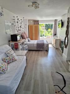 a living room with two beds and a large window at Luxurious Entire Studio in Axminster suitable for in Axminster