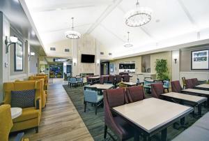 une salle à manger avec tables et chaises dans l'établissement Homewood Suites by Hilton Denver International Airport, à Aurora