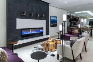 a living room with a fireplace and purple furniture at Hilton Garden Inn Longmont in Longmont