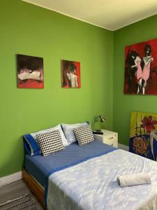 a bedroom with a bed and paintings on the wall at Résidence artistique Vue sur mer in Larache