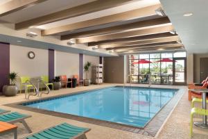 a pool in a hotel room with tables and chairs at Home2 Suites by Hilton Denver Highlands Ranch in Highlands Ranch