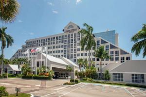 a large hotel with palm trees in a parking lot at DoubleTree by Hilton Hotel Deerfield Beach - Boca Raton in Deerfield Beach