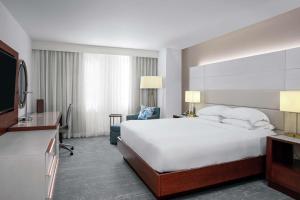 a hotel room with a large bed and a desk at DoubleTree by Hilton Hotel Deerfield Beach - Boca Raton in Deerfield Beach