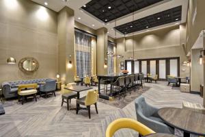 a lobby with tables and chairs and a waiting room at Hampton Inn & Suites Detroit/Warren in Warren