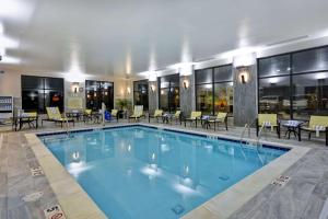 una gran piscina en un hotel con mesas y sillas en Hampton Inn & Suites Detroit/Warren en Warren