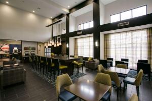 Hampton Inn & Suites Dallas/Ft. Worth Airport South في يوليس: مطعم بطاولات وكراسي وبار