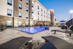 Hampton Inn & Suites Dallas/Ft. Worth Airport South في يوليس: فندق فيه مسبح كبير امام مبنى