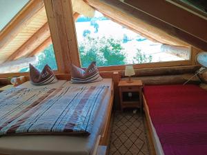 two beds in a room with a large window at Blockhaustraum in Titisee-Neustadt