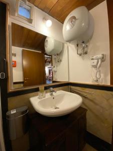 La salle de bains est pourvue d'un lavabo et d'un miroir. dans l'établissement Il Loft del Lago, à Anguillara Sabazia
