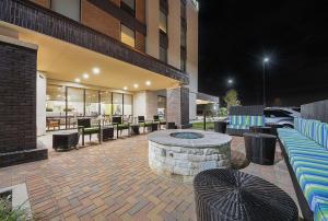 a building with a patio with a table and chairs at Home2 Suites By Hilton Dallas Grand Prairie in Grand Prairie
