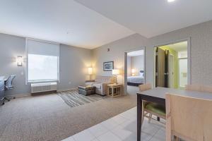 a living room with a room with a bed and a desk at Home2 Suites By Hilton Dallas Grand Prairie in Grand Prairie +30 photos