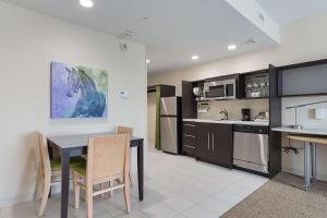 a kitchen and dining room with a table and chairs at Home2 Suites By Hilton Dallas Grand Prairie in Grand Prairie