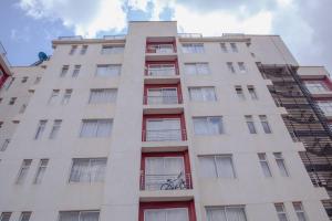 a tall white building with red windows and a bike at Stylish Studio on Ngong Road in Nairobi