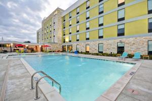 a large swimming pool in front of a building at Home2 Suites By Hilton Dallas Addison in Addison