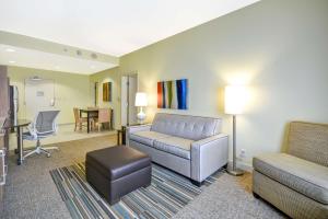 Home2 Suites By Hilton Dallas Addison في أديسون: غرفة معيشة مع أريكة وكرسي