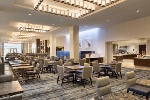 um restaurante com mesas e cadeiras no átrio em Embassy Suites By Hilton Denton Convention Center em Denton