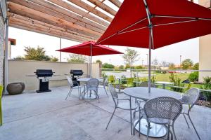 Home2 Suites By Hilton Fort Worth Southwest Cityview في فورت وورث: فناء به طاولات وكراسي وبيانو