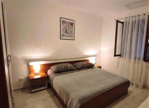 a bedroom with a bed with two pillows on it at Apartmani Karmen Mali Maj in Poreč