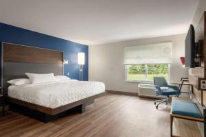 德卢斯Tru By Hilton Duluth Mall Area的一间卧室，配有一张床、一张桌子和一把椅子 更多25张照片