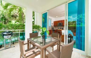 una sala de estar abierta con mesa de cristal y sillas. en Grand Laguna Beach Properties by Calisto Stays, en Sosúa