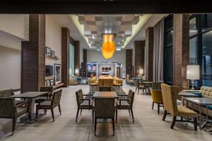a restaurant with tables and chairs in a lobby at Hampton Inn & Suites Dallas-The Colony in The Colony