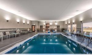 a pool in a hotel with tables and chairs at Hampton Inn & Suites Dallas-The Colony in The Colony