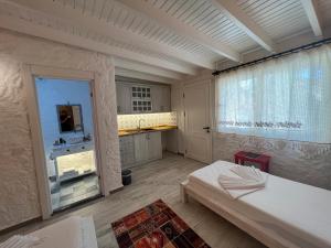 a room with a bed and a kitchen with a window at ALAÇATI XL LUXURY HOTEL in Cesme