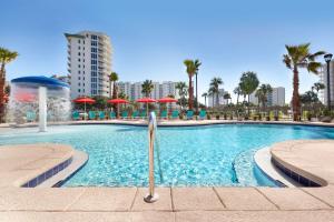 - une piscine avec une fontaine et des palmiers dans l'établissement Home2 Suites by Hilton Destin, à Destin