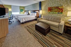 een hotelkamer met een bed, een bank en een televisie bij Home2 Suites by Hilton Destin in Destin