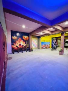 ein großes leeres Zimmer mit Gemälden an den Wänden in der Unterkunft Golden Lotus Varanasi in Varanasi