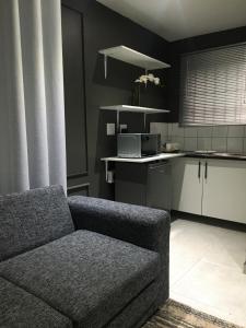 a living room with a couch and a kitchen at Black Rose Guesthouse in Soweto