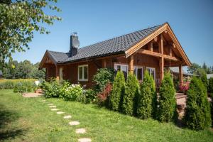 a wooden house with a garden in front of it at Brzozowa Aleja in Radawa