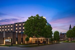 un rendimiento de un edificio con un árbol delante en Home2 Suites by Hilton Des Moines at Drake University en Des Moines