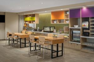 um restaurante com um bar com mesas e cadeiras em Home2 Suites by Hilton Des Moines at Drake University em Des Moines