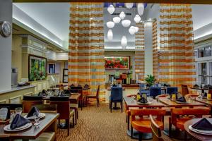 Hilton Garden Inn Danbury في دانبري: غرفة طعام مع طاولات وكراسي ومطعم