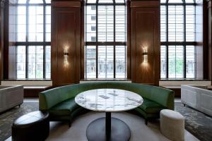 a living room with a green couch and a table at Hotel Fort Des Moines, Curio Collection By Hilton in Des Moines