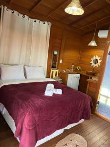 1 dormitorio con 1 cama con 2 toallas en Pousada BANGALÔS SOL DE LAGOINHA, en Paraipaba